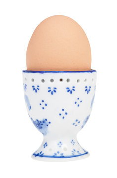 brown boiled egg in cup with a pointy end up