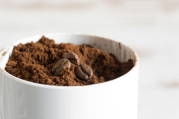 Ground coffee with coffee beans on top in a coffee grinder closeup. Preparing coffee close up.