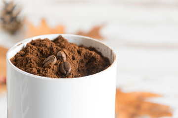 Ground coffee with coffee beans on top in a coffee grinder closeup. Preparing coffee close up.