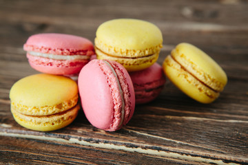 Sweet colorful French macaroon cookies dessert on brown wooden table