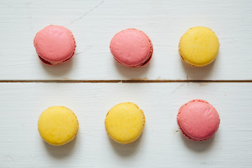 Sweet colorful French macaroon cookies dessert on white wooden table