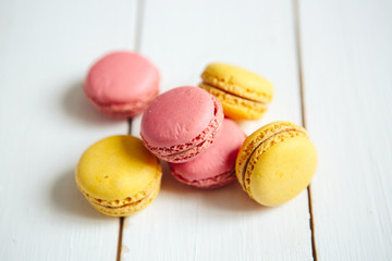 Sweet colorful French macaroon cookies dessert on white wooden table