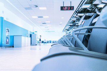 Empty seat in modern building with blurry woman stading in front of automatic vending machine.