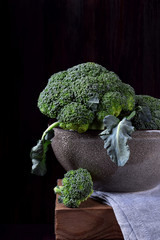 Raw broccoli cabbage in a bowl against black background