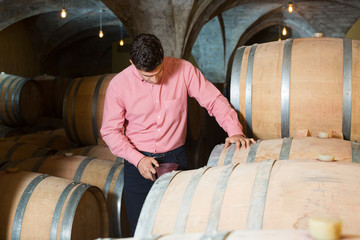 Man posing in winery cellar
