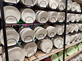 Dishes and bowls are sold on shelves in a supermarket. Organized by category to facilitate customers.