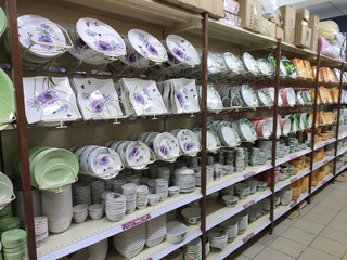 Dishes and bowls are sold on shelves in a supermarket. Organized by category to facilitate customers.