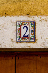 Decorative street number plate from facade of old house in Nimes, France