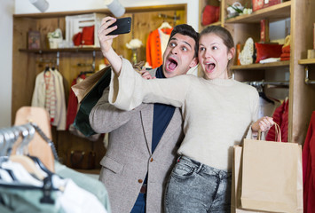 Fototapeta premium Couple is satisfied shopping and taking selfie