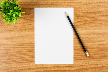 blank note paper and a pencil on wooden desk. - blank space for advertising text.