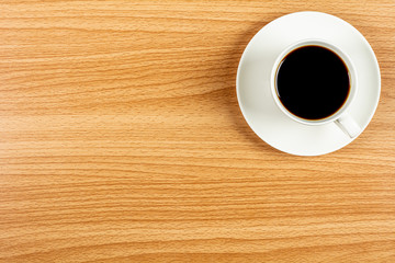 white ceramic coffee cup on wooden desk. - blank space for advertising text.
