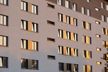 Windows reflecting sunlight at sunset in a modern multi-storey building.