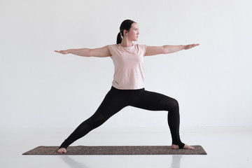 Caucasian woman doing warrior pose two from yoga. Standing position for strong legs.