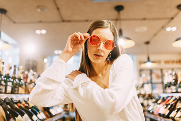 portrait of a stylish girl in sunscreen. modern interior of the wine bar.