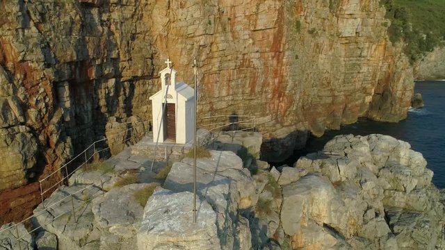 Isolated Little White Church Chapel On Cliffs Near The Coast Of Montenegro, Aerial Drone Orbit.