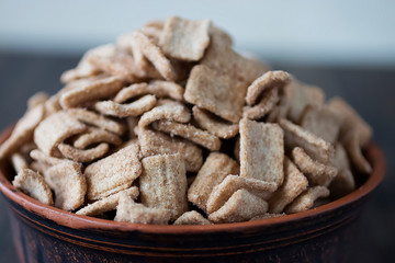 Whole grain cinnamon flakes in a brown bowl. Breakfast cereals. The concept of a quick and healthy breakfast.