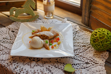 cake on a white plate on an embroidered napkin on the windowsill