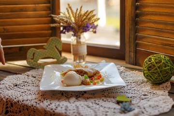 cake on a white plate on an embroidered napkin on the windowsill