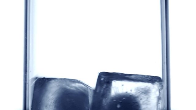 Throw ice cubes in empty glass. Icecubes falling down in cup