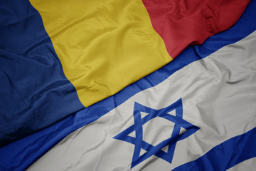 waving colorful flag of israel and national flag of romania.