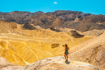 A young woman in dress enjoying the view of the viewpoint of Zabriskie Point, California. United States