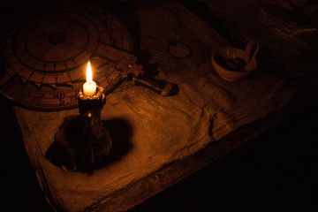 Ancient medieval instruments illuminated by a candle