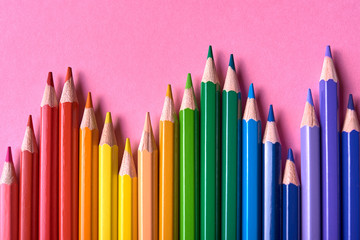 Color pencils on pink pastel background, close up. Set of colorful pencils, copy space. Crayons. Top view, flat lay. Back to school, college concept. Abstract background