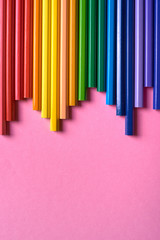 Color pencils on pink pastel background, close up. Set of colorful pencils, copy space. Crayons. Top view, flat lay. Back to school, college concept. Abstract background