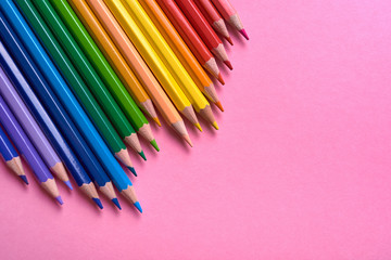 Color pencils on pink pastel background, close up. Set of colorful pencils, copy space. Crayons. Top view, flat lay. Back to school, college concept. Abstract background