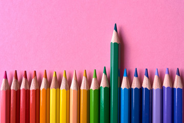 Color pencils on pink pastel background, close up. Set of colorful pencils, copy space. Crayons. Top view, flat lay. Back to school, college concept. Abstract background