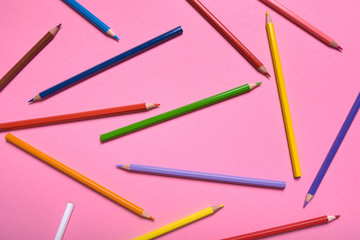 Color pencils on pink pastel background, close up. Set of colorful pencils, copy space. Crayons. Top view, flat lay. Back to school, college concept. Abstract background