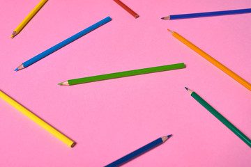 Color pencils on pink pastel background, close up. Set of colorful pencils, copy space. Crayons. Top view, flat lay. Back to school, college concept. Abstract background