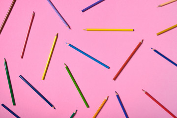 Color pencils on pink pastel background, close up. Set of colorful pencils, copy space. Crayons. Top view, flat lay. Back to school, college concept. Abstract background
