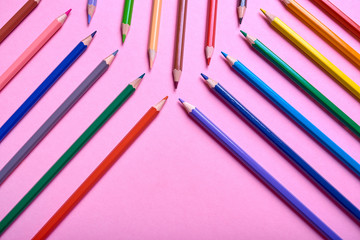 Color pencils on pink pastel background, close up. Set of colorful pencils, copy space. Crayons. Top view, flat lay. Back to school, college concept. Abstract background