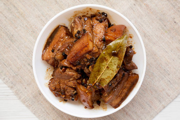 Homemade Filipino Adobo Pork in a bowl, top view. Flat lay, from above, overhead. Close-up.