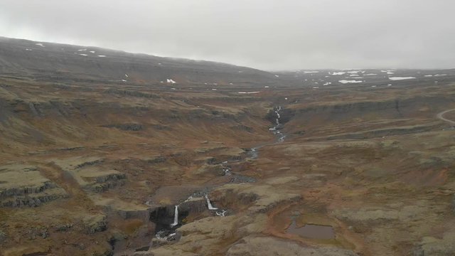 Fossa River Berufjordur in Icelandic highlands overcast day, aerial pull away