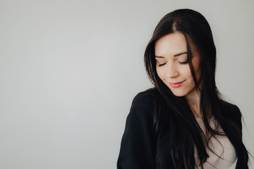 Obraz premium Young attractive emotional girl in business-style clothes on a plain white background in an office or audience
