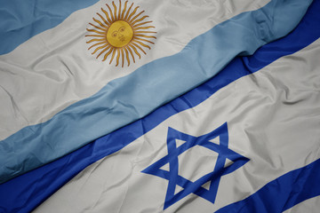 waving colorful flag of israel and national flag of argentina.