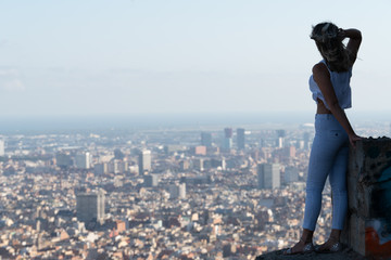young beautiful caucasian woman looking at the city from the heights