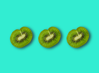 Three halves of sliced kiwi, with shadow.