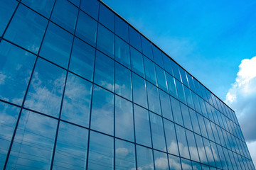 Fototapeta na wymiar reflection of the blue sky in the Windows of the business center close-up