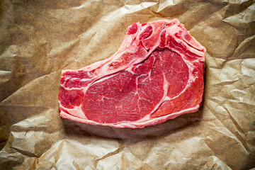 Fresh, huge and appetizing club steak on brown paper