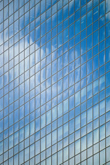 Fototapeta na wymiar Skyscraper, in glass windows reflects blue sky. Modern architecture background