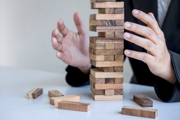 Alternative Risk and Strategy in business, Business woman's hands protect balance wooden stack with...