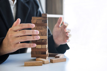 Alternative Risk and Strategy in business, Business woman's hands protect balance wooden stack with...