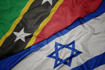 waving colorful flag of israel and national flag of saint kitts and nevis.