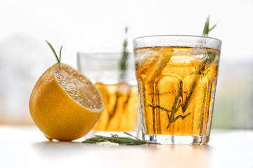 glasses of soda with lemon and rosemary on a light background