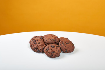 Four delicious, brown gingerbread lie on a white table, behind