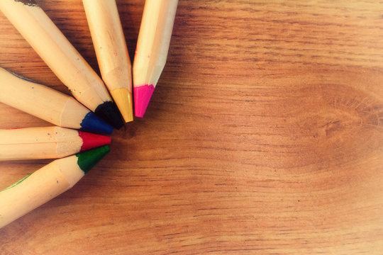 Lapices de colores en una esquina sobre un fondo de madera