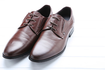 Male leather shoes on white wooden table